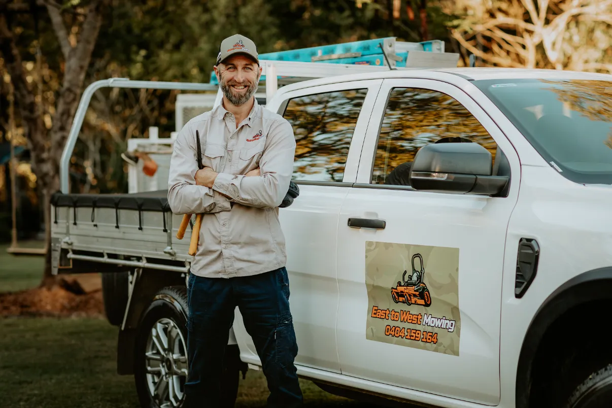 Man with garden sheers, standing in front of his work ute.